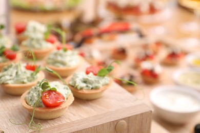 Photo of Buffet menu. Tasty stuffed tartlets on stand, closeup