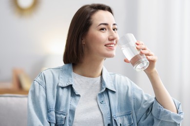 Photo of Young woman drinking water from at home