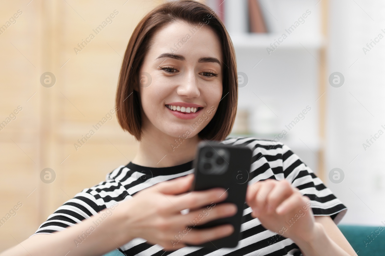 Beautiful woman using modern smartphone at home Photo of Beautiful woman using modern smartphone at home