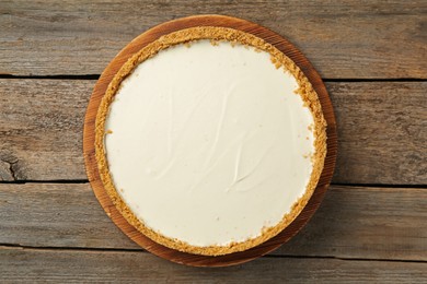 Photo of One tasty cheesecake on wooden table, top view