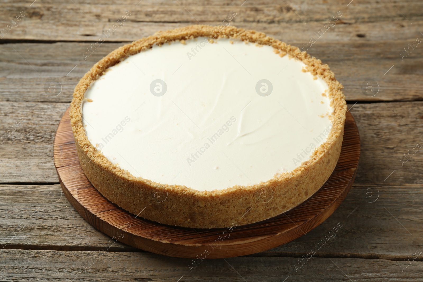 Photo of One tasty cheesecake on wooden table, closeup