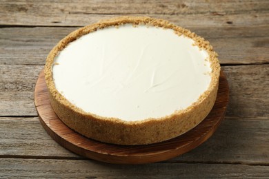 Photo of One tasty cheesecake on wooden table, closeup