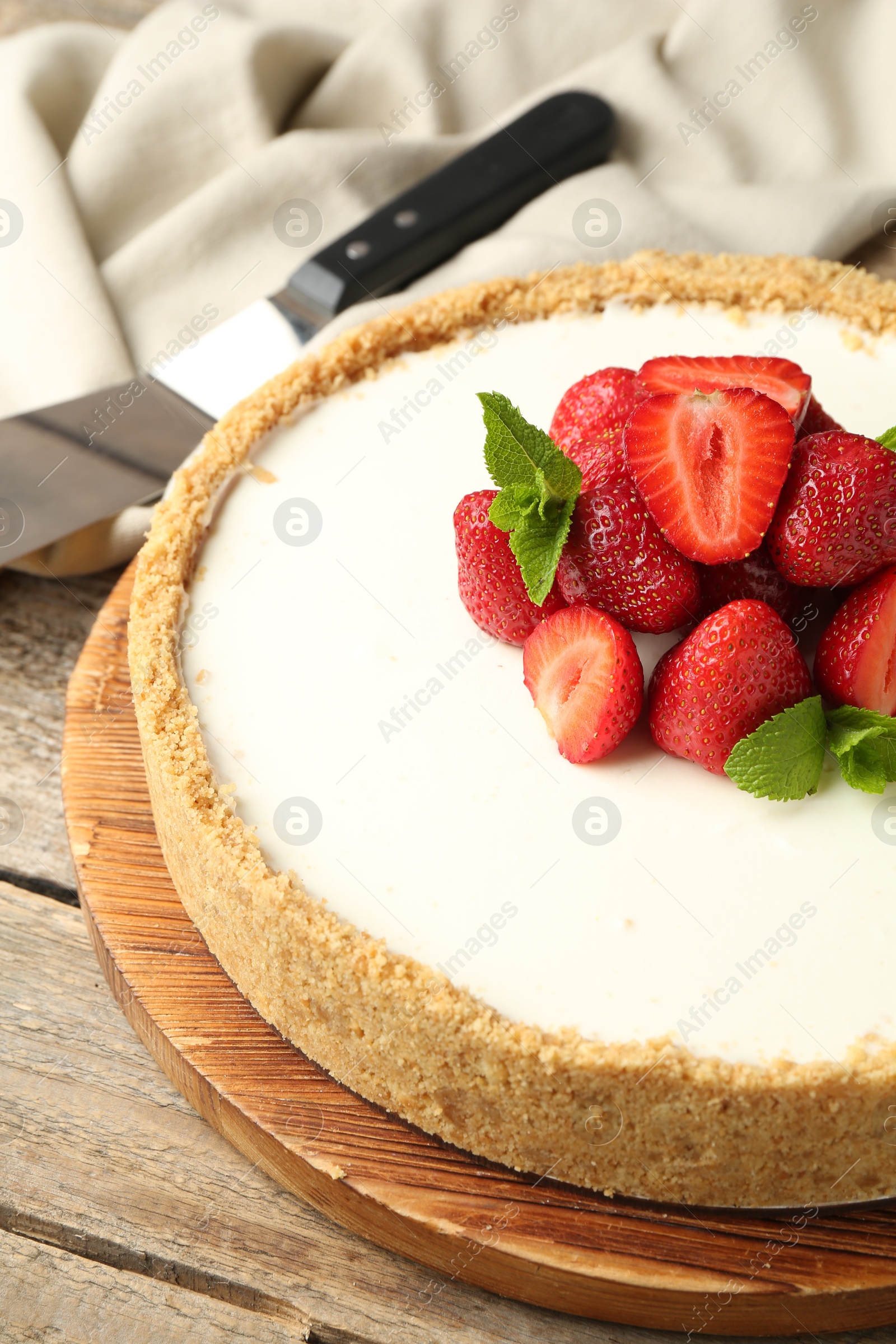 Tasty cheesecake with strawberries and mint on wooden table, closeup Photo of Tasty cheesecake with strawberries and mint on wooden table, closeup