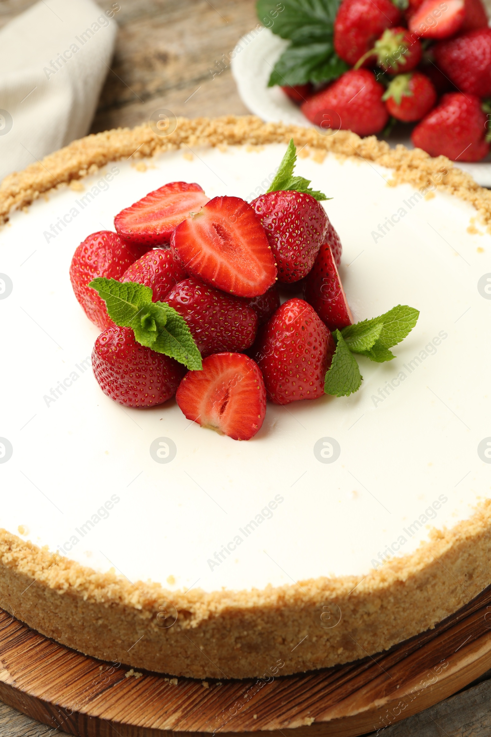 Tasty cheesecake with strawberries and mint on wooden table, closeup Photo of Tasty cheesecake with strawberries and mint on wooden table, closeup