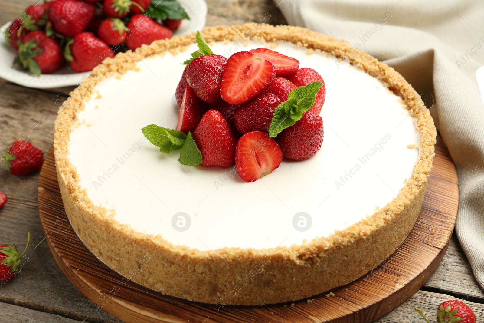 Tasty cheesecake with strawberries and mint on wooden table, closeup Photo of Tasty cheesecake with strawberries and mint on wooden table, closeup