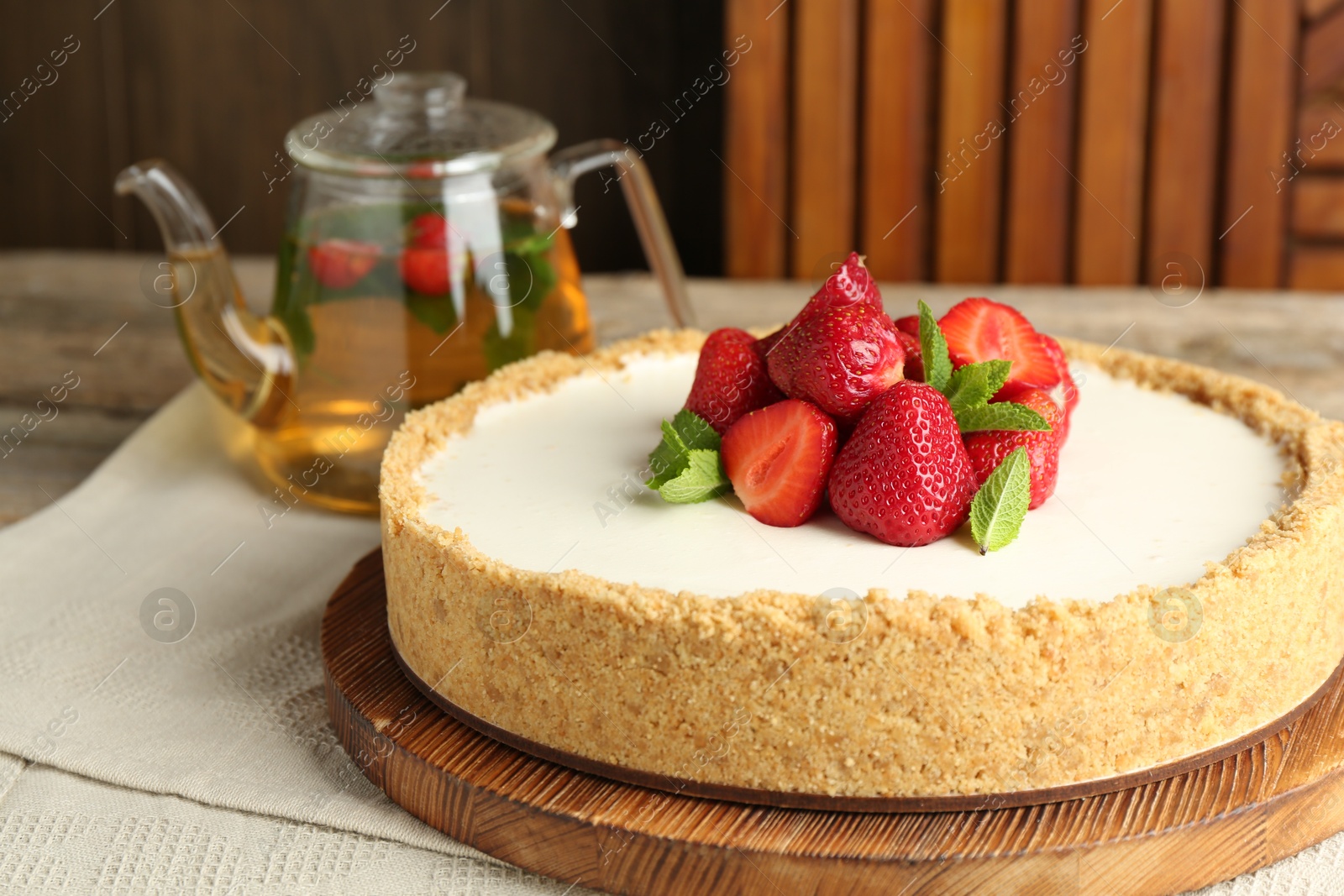 Tasty cheesecake with strawberries and mint on wooden table, closeup Photo of Tasty cheesecake with strawberries and mint on wooden table, closeup