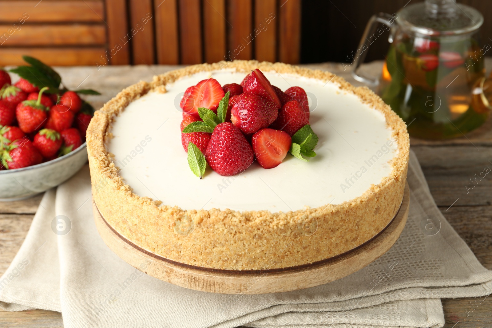 Tasty cheesecake with strawberries and mint on wooden table, closeup Photo of Tasty cheesecake with strawberries and mint on wooden table, closeup
