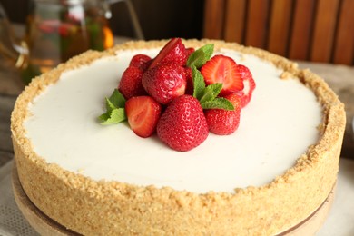 Photo of Tasty cheesecake with strawberries and mint on table, closeup