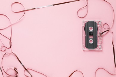 Photo of Frame made of magnetic tape from audio cassette on pink background, top view. Space for text