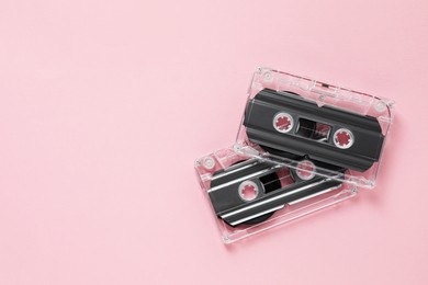 Photo of Audio cassettes with magnetic tapes on pink background, flat lay. Space for text