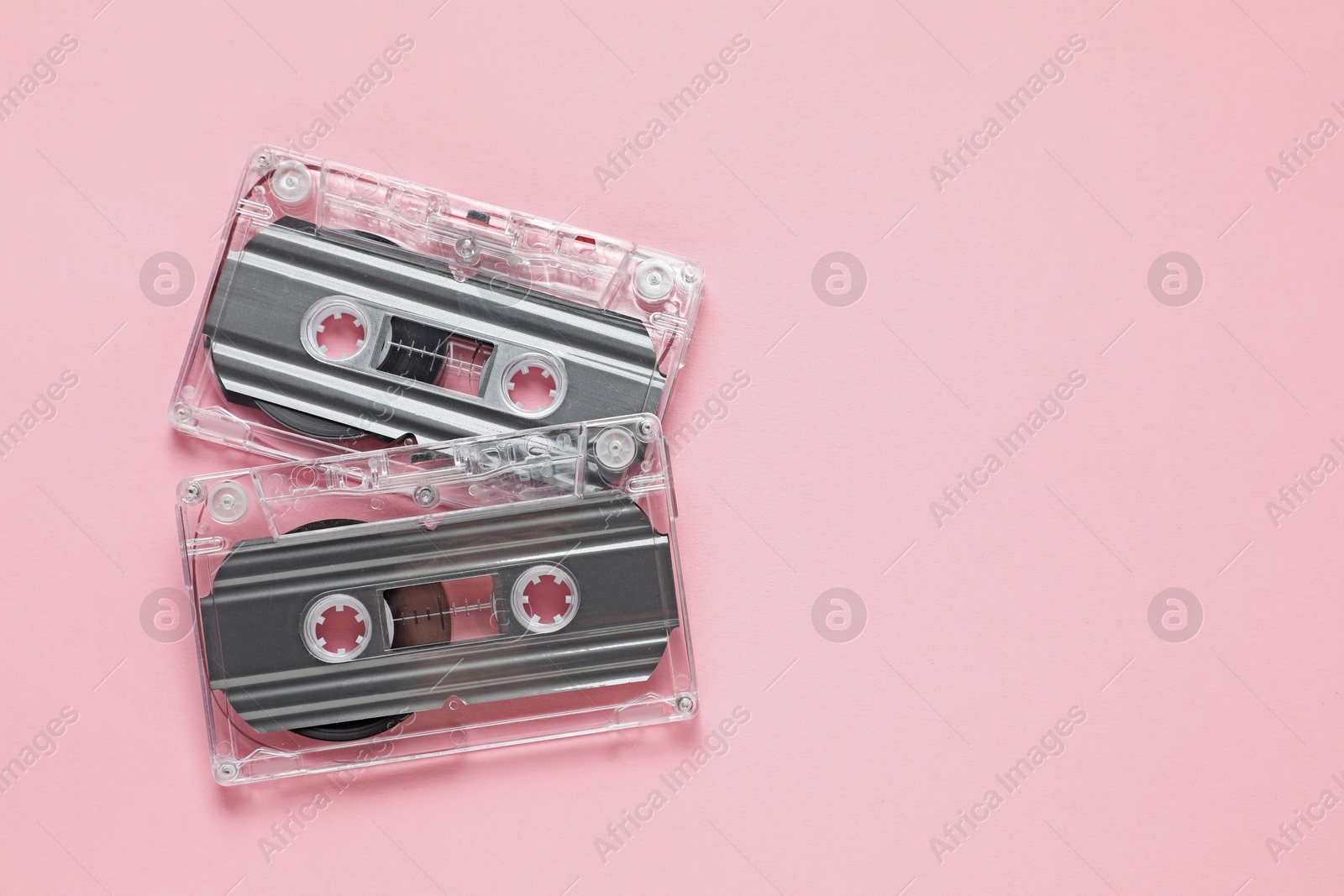 Audio cassettes with magnetic tapes on pink background, flat lay. Space for text Photo of Audio cassettes with magnetic tapes on pink background, flat lay. Space for text