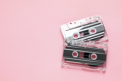 Photo of Audio cassettes with magnetic tapes on pink background, flat lay. Space for text