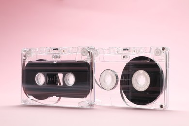 Photo of Audio cassettes with magnetic tapes on pink background, closeup