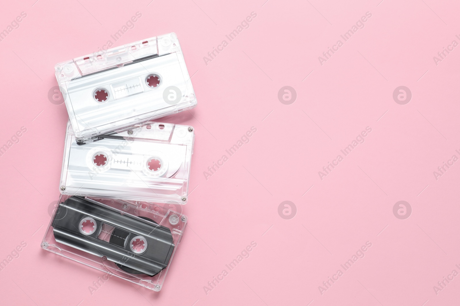 Audio cassettes with magnetic tapes on pink background, flat lay. Space for text Photo of Audio cassettes with magnetic tapes on pink background, flat lay. Space for text