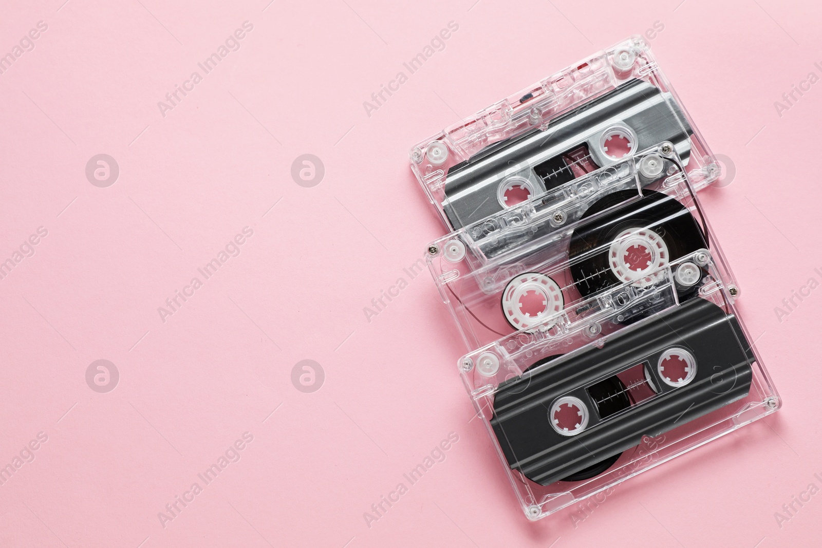 Audio cassettes with magnetic tapes on pink background, flat lay. Space for text Photo of Audio cassettes with magnetic tapes on pink background, flat lay. Space for text
