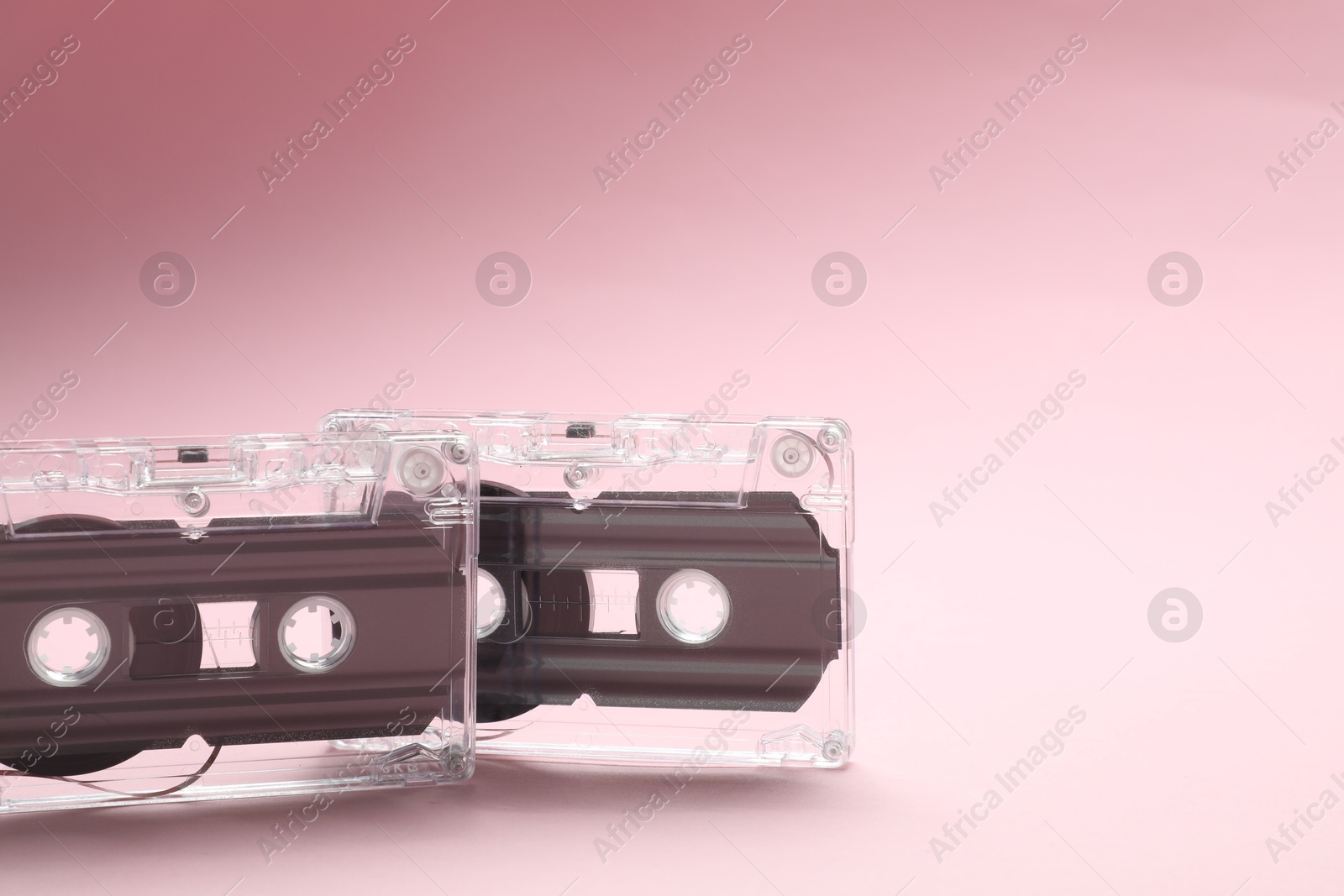 Audio cassettes with magnetic tapes on pink background, closeup. Space for text Photo of Audio cassettes with magnetic tapes on pink background, closeup. Space for text