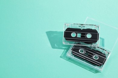 Photo of Audio cassettes with magnetic tapes on turquoise background, above view. Space for text