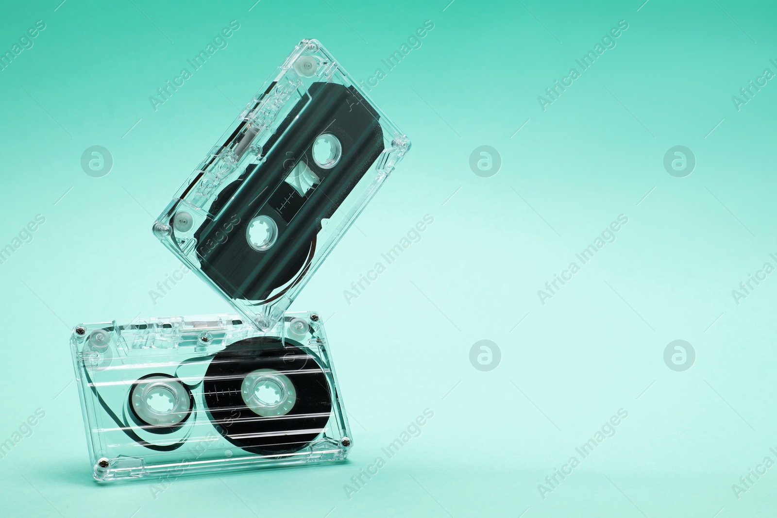 Audio cassettes in air on turquoise background, closeup. Space for text Photo of Audio cassettes in air on turquoise background, closeup. Space for text