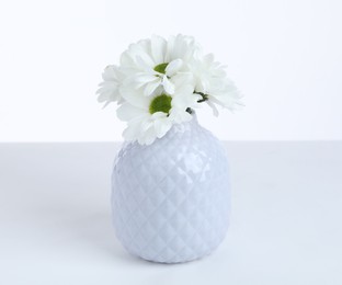 Photo of Beautiful chrysanthemums in ceramic vase on white background