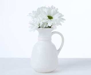 Photo of Beautiful chrysanthemums in ceramic vase isolated on white