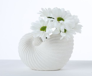 Photo of Beautiful chrysanthemums in ceramic vase isolated on white