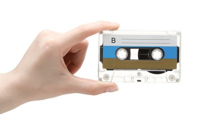 Photo of Woman holding audio cassette with blank label on white background, closeup