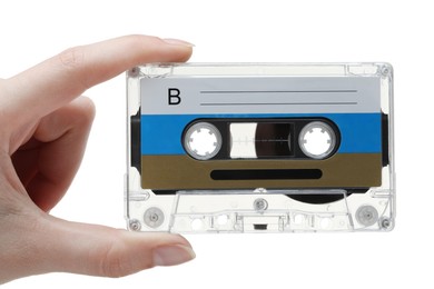 Photo of Woman holding audio cassette with blank label on white background, closeup