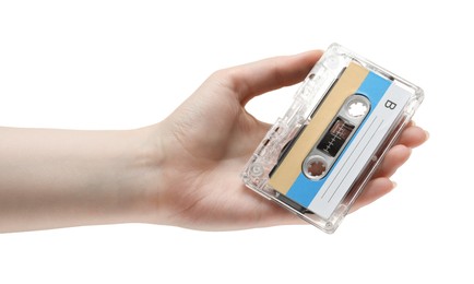 Photo of Woman holding audio cassette with blank label on white background, closeup