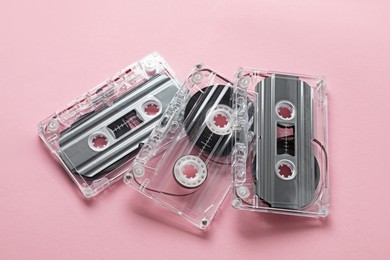 Photo of Audio cassettes with magnetic tapes on pink background, above view