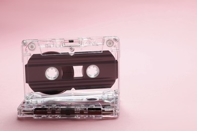 Photo of Audio cassettes with magnetic tapes on pink background, closeup. Space for text