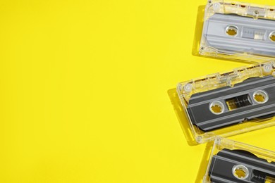 Photo of Audio cassettes with magnetic tapes on yellow background, above view. Space for text