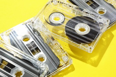 Photo of Audio cassettes with magnetic tapes on yellow background, closeup