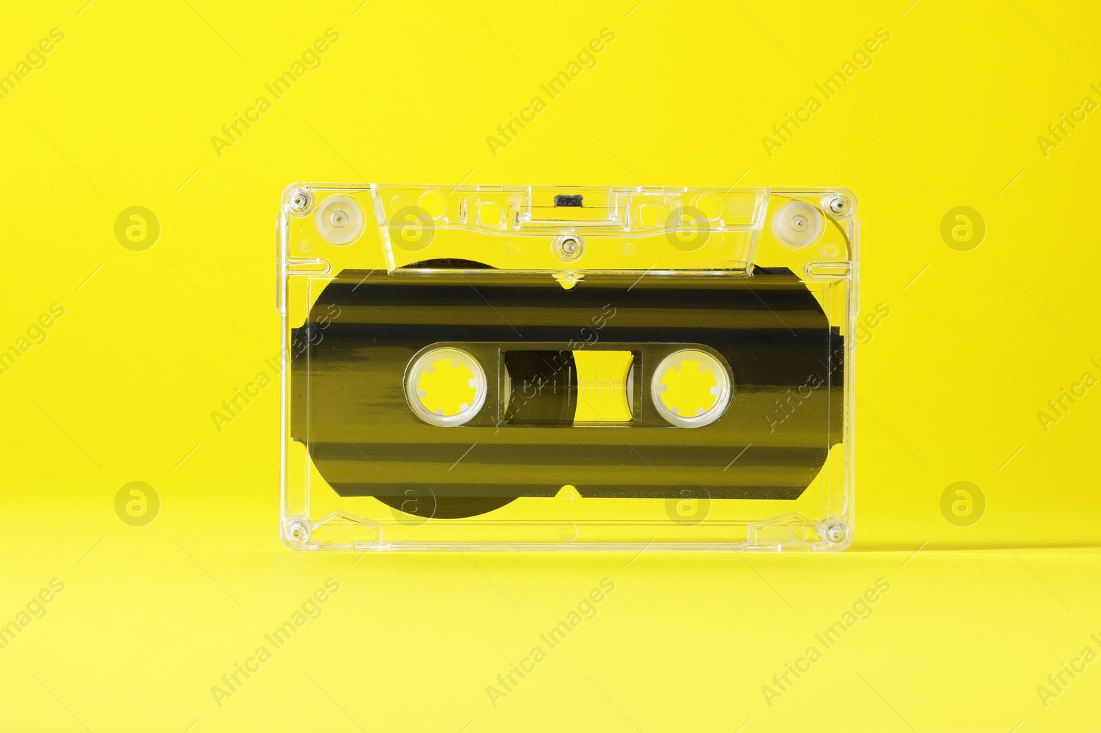 One audio cassette with magnetic tape on yellow background, closeup Photo of One audio cassette with magnetic tape on yellow background, closeup