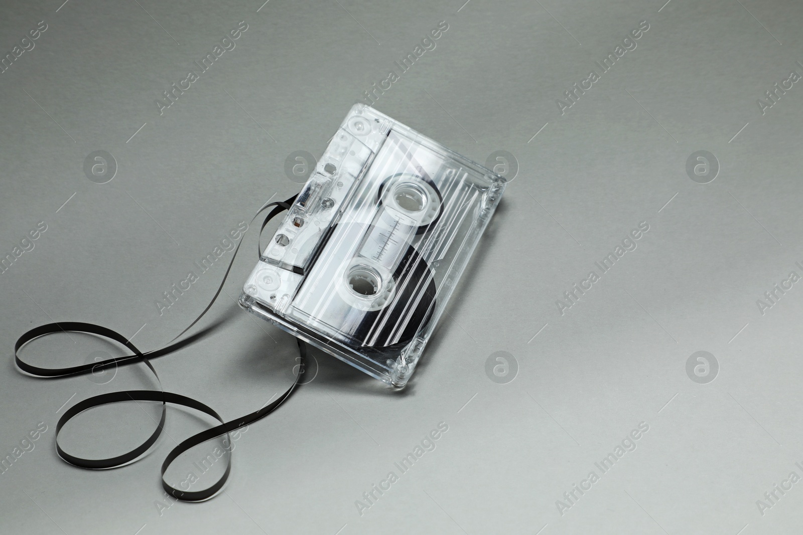One audio cassette with magnetic tape on grey background, closeup Photo of One audio cassette with magnetic tape on grey background, closeup