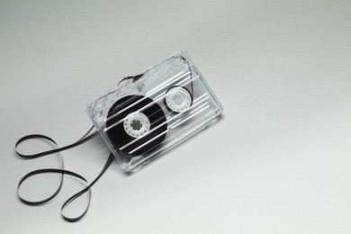 Photo of One audio cassette with magnetic tape on grey background, above view