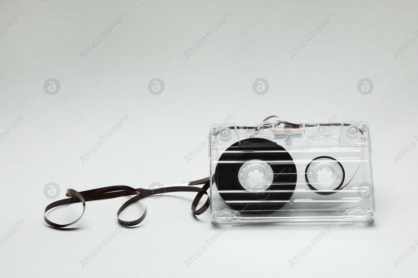 One audio cassette with magnetic tape on light grey background, closeup Photo of One audio cassette with magnetic tape on light grey background, closeup