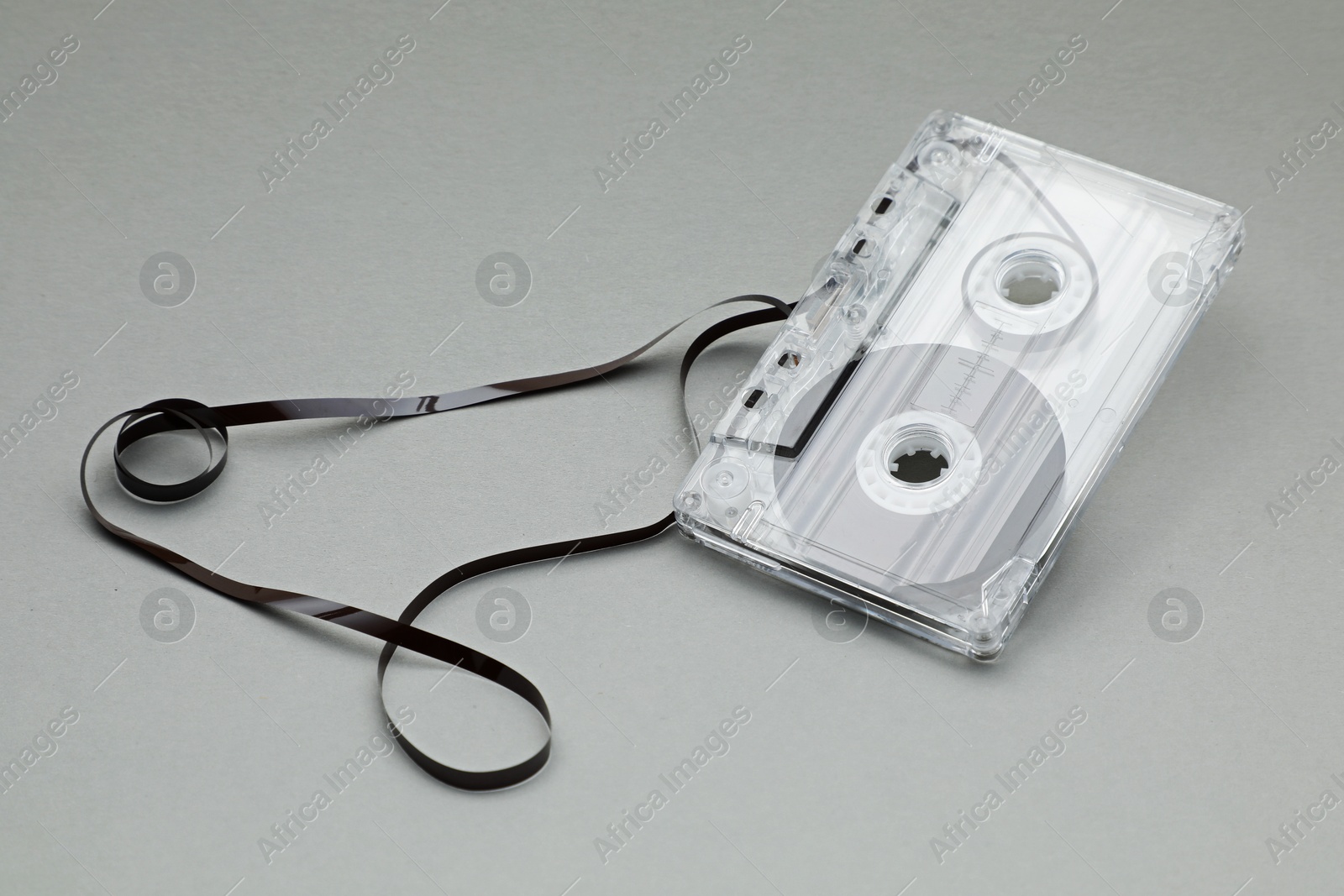 One audio cassette with magnetic tape on grey background, closeup Photo of One audio cassette with magnetic tape on grey background, closeup