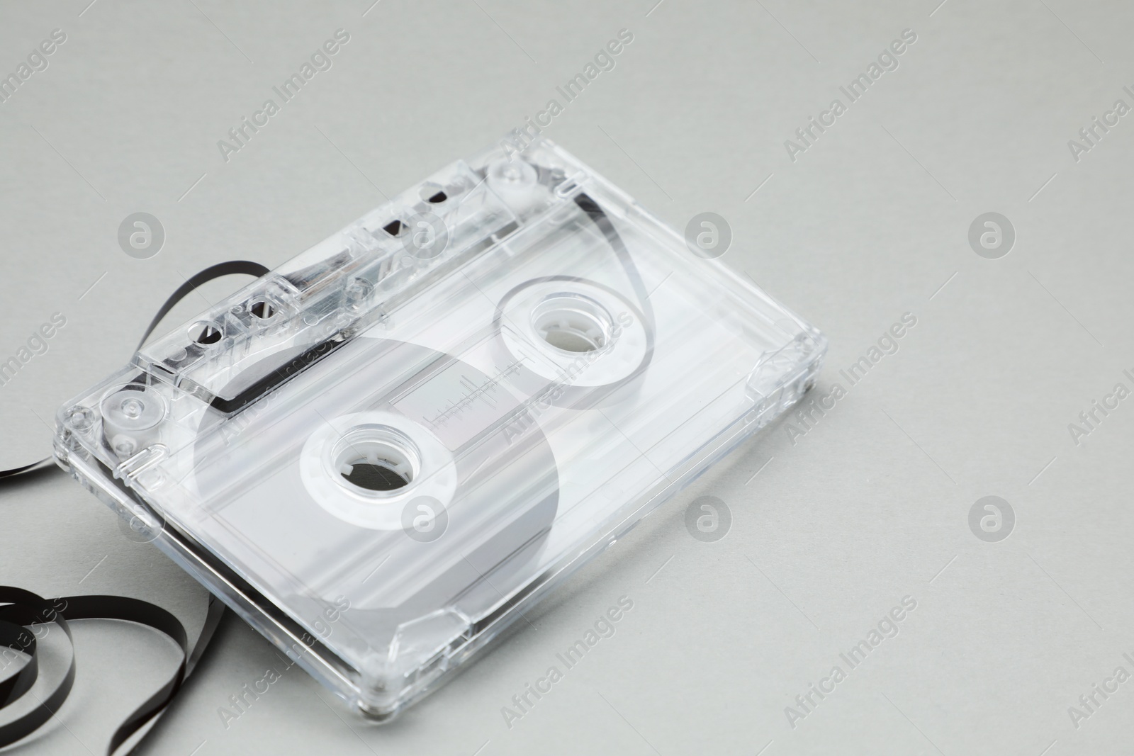 One audio cassette with magnetic tape on grey background, closeup Photo of One audio cassette with magnetic tape on grey background, closeup