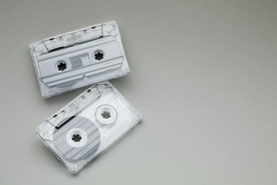 Photo of Audio cassettes with magnetic tapes on grey background, flat lay. Space for text