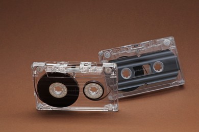 Photo of Audio cassettes with magnetic tapes on brown background, closeup