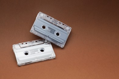 Photo of Audio cassettes with magnetic tapes on brown background. Space for text
