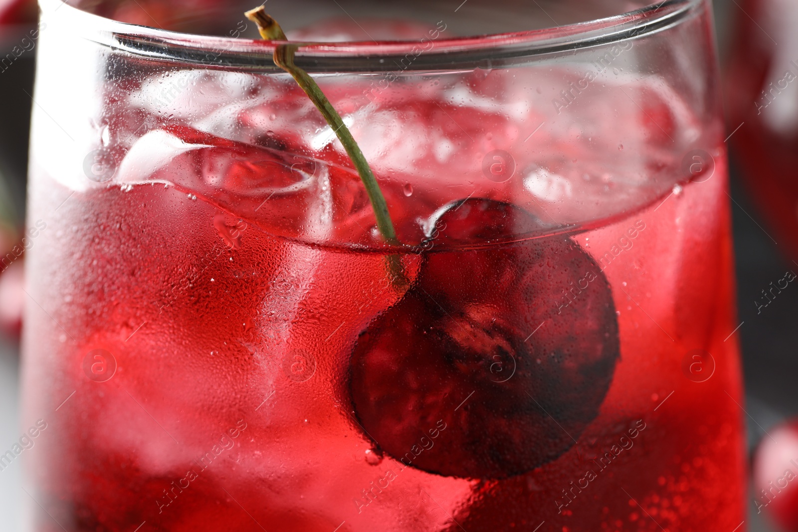 Tasty cherry soda with ice cubes and berry in glass, closeup Photo of Tasty cherry soda with ice cubes and berry in glass, closeup