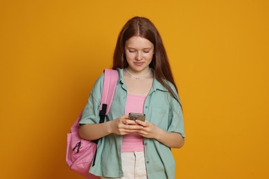Photo of Teenage girl with smartphone on yellow background