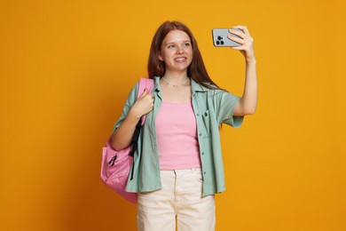 Photo of Teenage girl taking selfie on yellow background