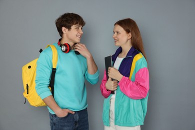 Photo of Teenagers with backpack and laptop on grey background
