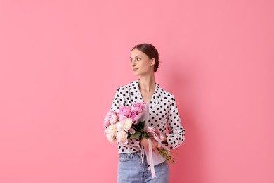 Photo of Woman with beautiful bouquets of peonies on pink background