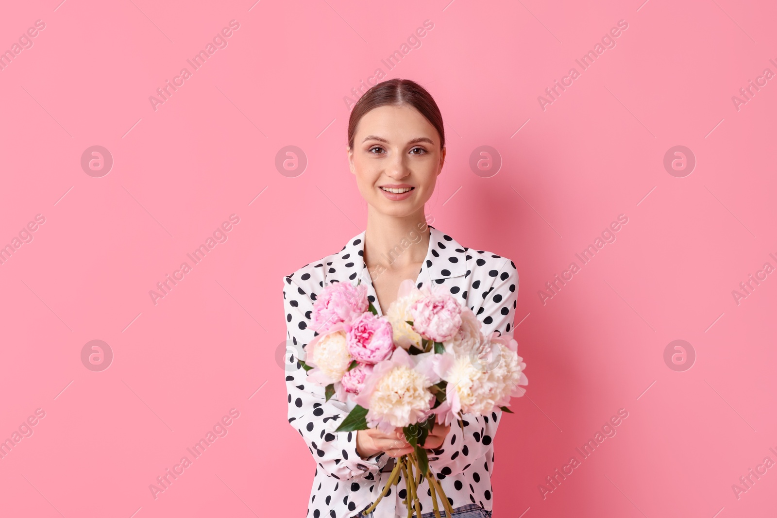 Woman with beautiful bouquet of peonies on pink background Photo of Woman with beautiful bouquet of peonies on pink background