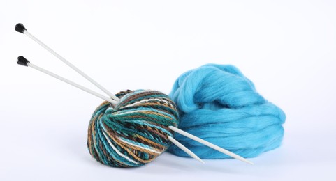 Photo of Felting wool, knitting yarn and needles isolated on white