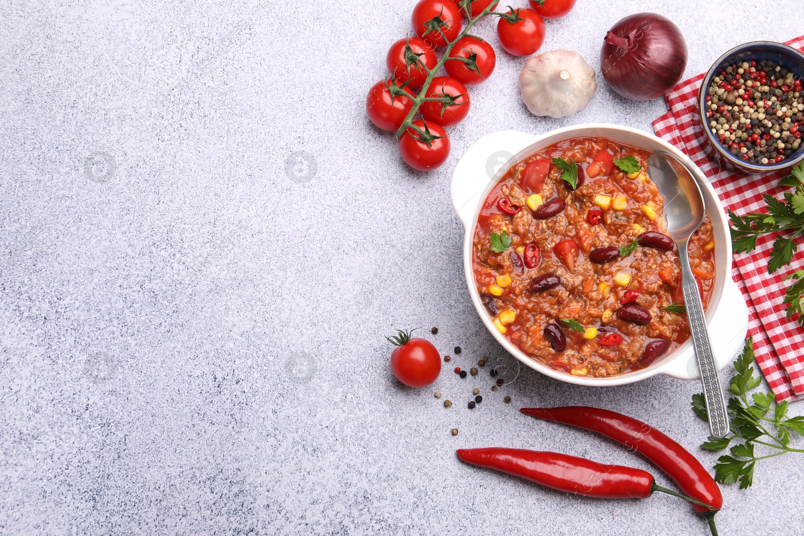 Tasty chili con carne in bowl and ingredients on grey table, flat lay. Space for text Photo of Tasty chili con carne in bowl and ingredients on grey table, flat lay. Space for text