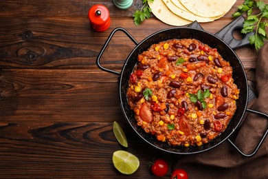 Photo of Tasty chili con carne in baking dish and flatbread on wooden table, flat lay. Space for text